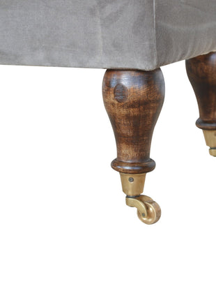 Banco de terciopelo gris con patas con ruedas