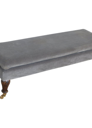 Banco de terciopelo gris con patas con ruedas