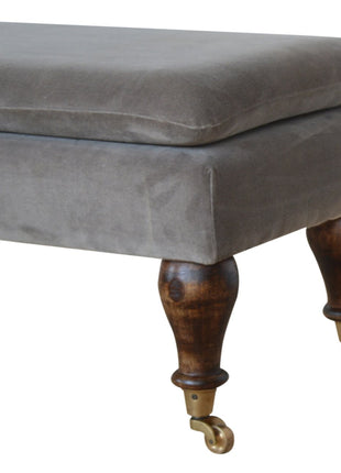 Banco de terciopelo gris con patas con ruedas